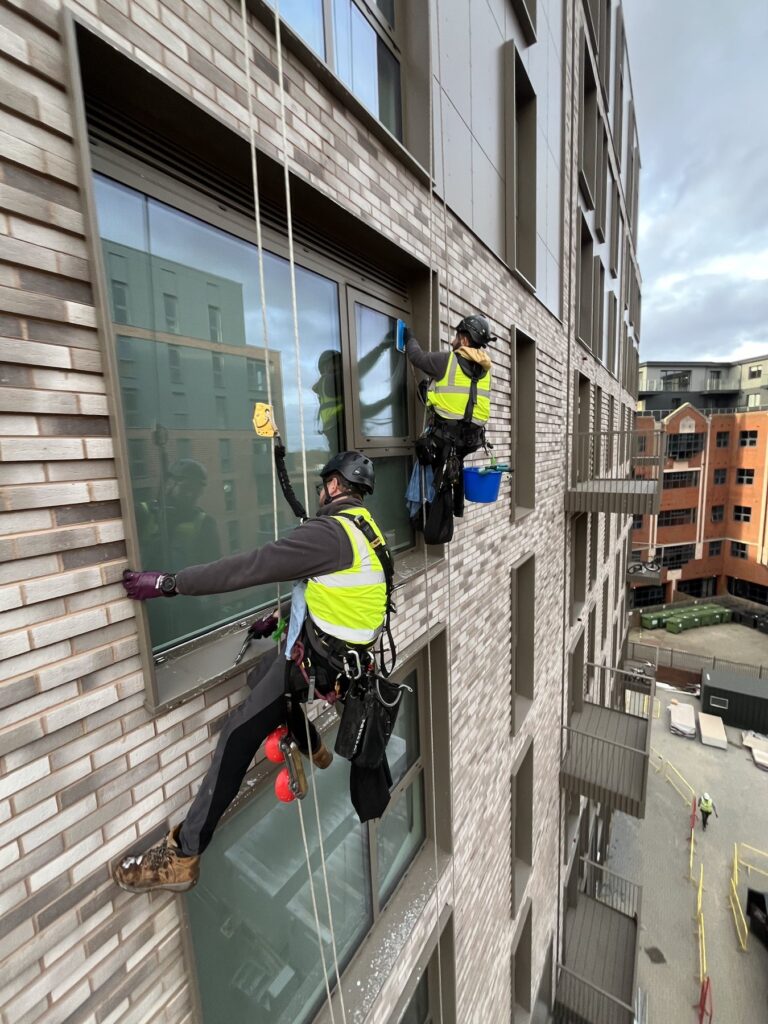 Ropeguys technicians carrying out builders window cleaning by rope access on a high-rise building in Peterborough