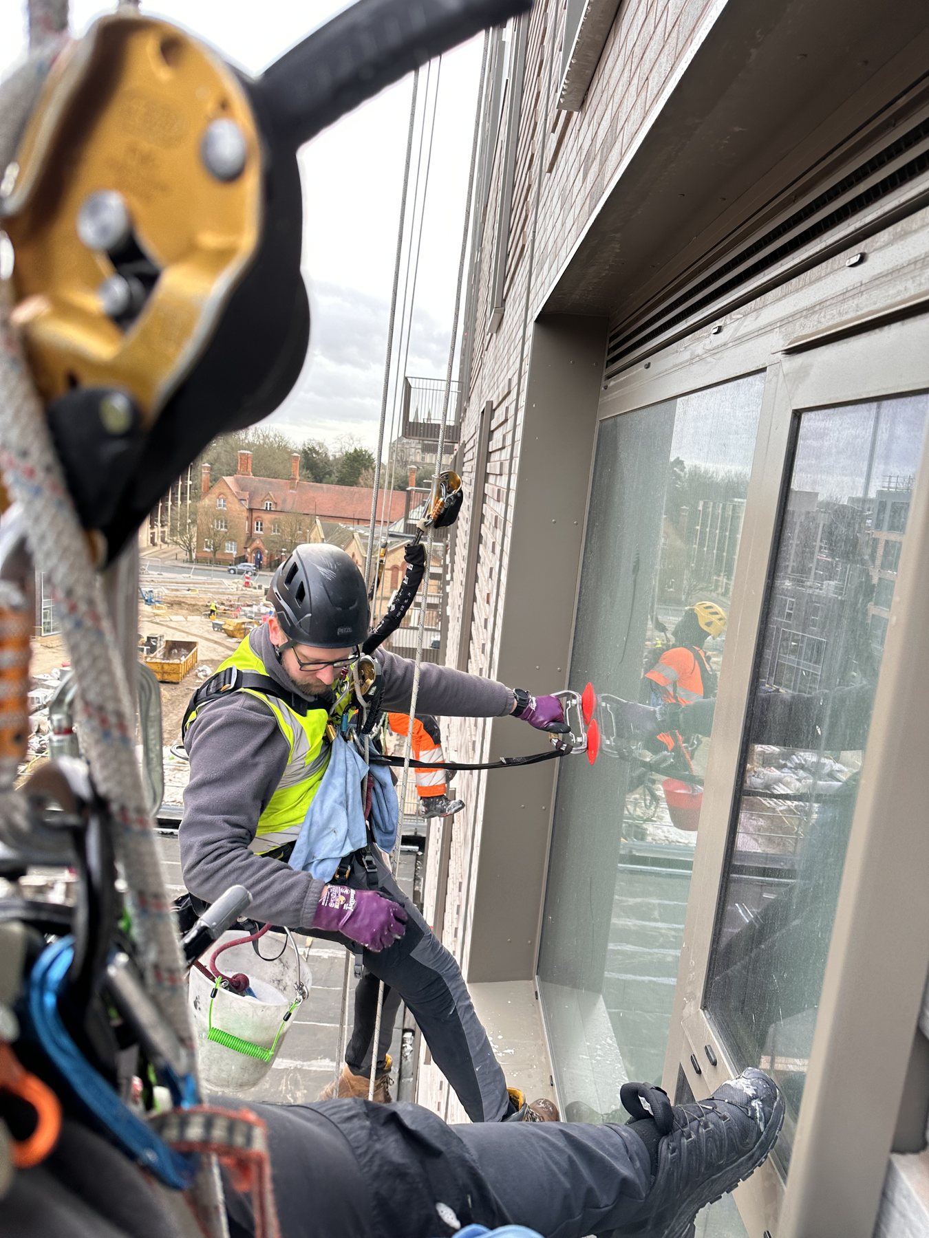 High rise window cleaning using rope access and a davit system